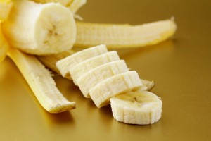 Ripe banana cut into slices on a gold background